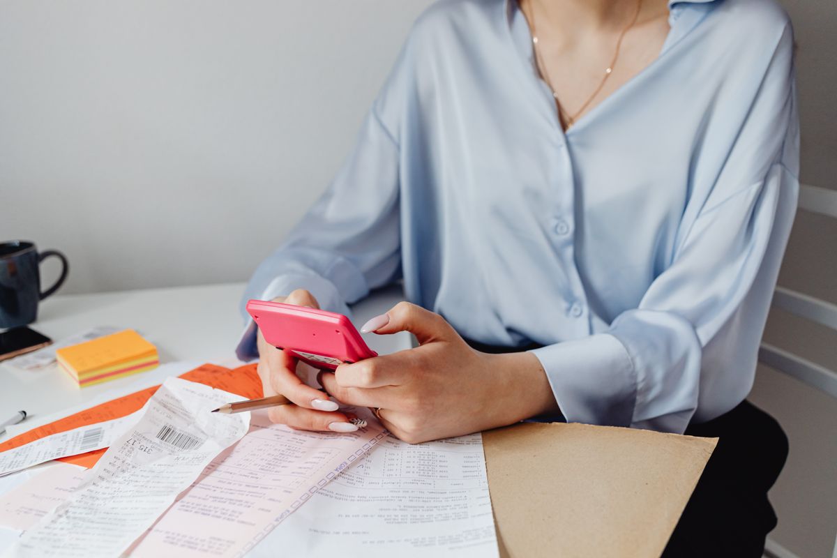 Calculating expenses with a calculator and receipts on a desk.